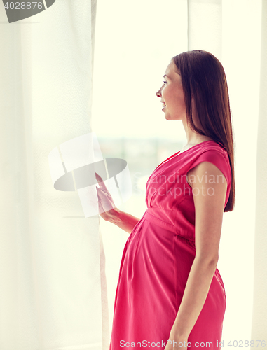 Image of happy pregnant woman with big tummy at home