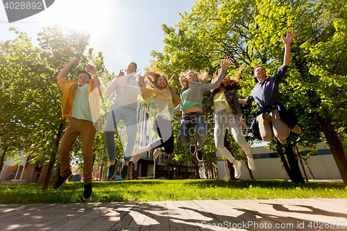 Image of happy teenage students or friends jumping outdoors