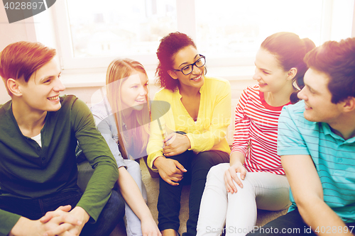 Image of five smiling teenagers having fun at home