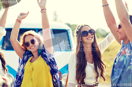 Image of happy young hippie friends dancing outdoors