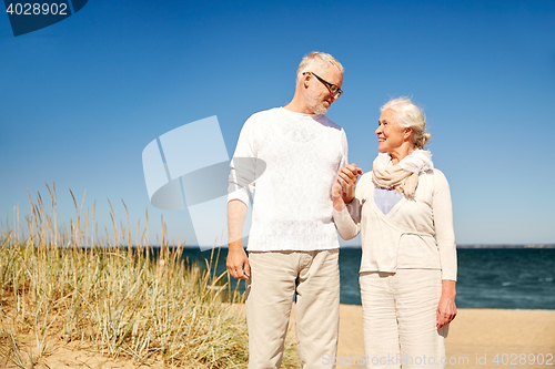 Image of happy senior couple talking on summer beach