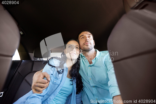 Image of happy man and woman hugging in car