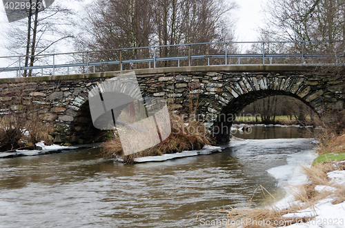 Image of old stonebridge over the cold water in sweden