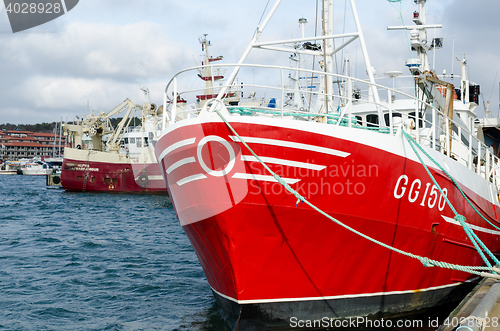 Image of one red fishing boat in harbour