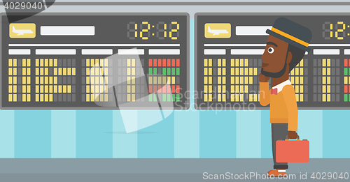 Image of Man looking at departure board in the airport.