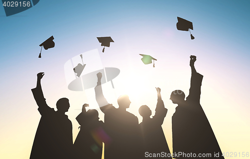 Image of silhouettes of students throwing mortarboards