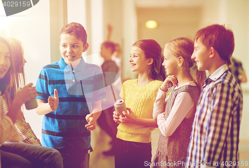 Image of group of school kids with soda cans in corridor