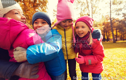 Image of group of happy children hugging in autumn park