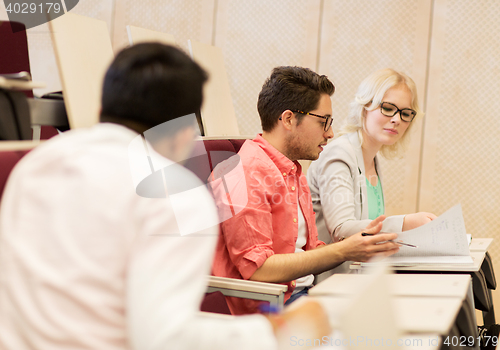 Image of group of students with notebooks in lecture hall