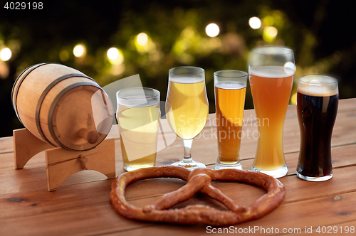 Image of close up of beer glasses, barrel and pretzel