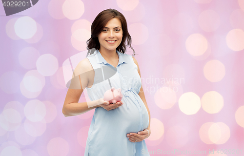 Image of happy pregnant woman with piggybank