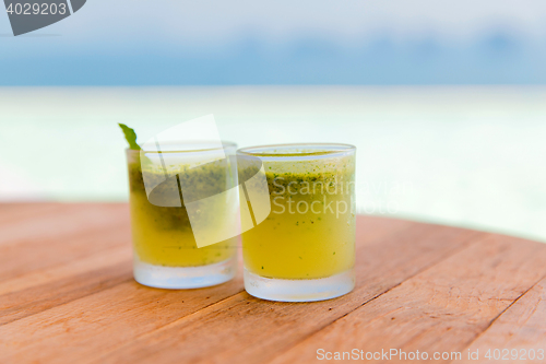 Image of glasses of fresh juice or cocktail on beach