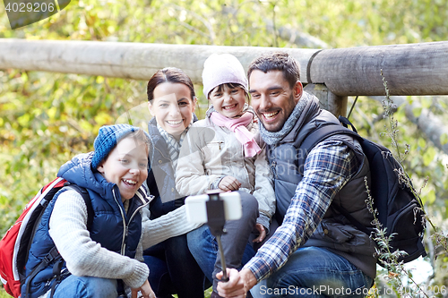 Image of happy family with smartphone selfie stick in woods