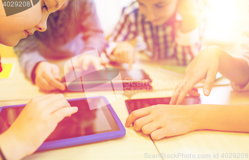 Image of close up of school kids playing with tablet pc 