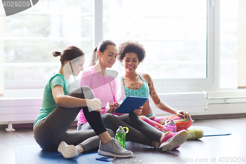 Image of group of happy women with tablet pc in gym