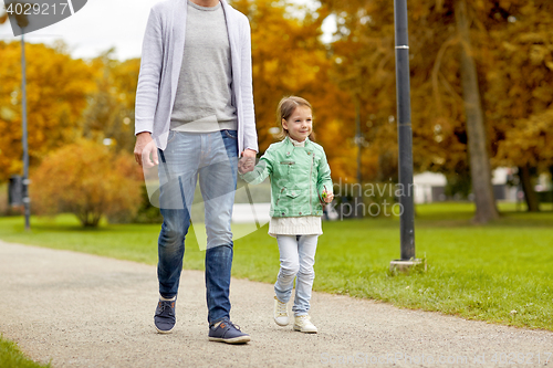 Image of happy family walking in summer park