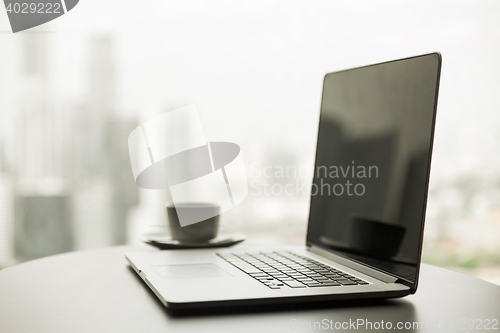 Image of close up of laptop and coffee cup on office table