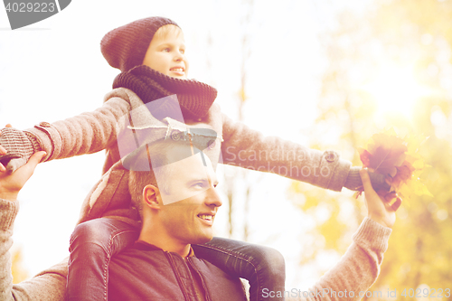 Image of happy family having fun in autumn park