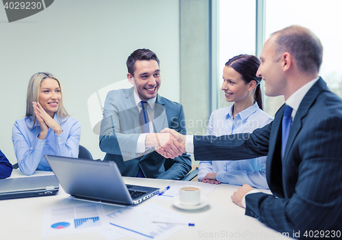 Image of two businessman shaking hands in office
