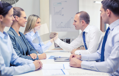 Image of businesswoman and businessman arm wrestling