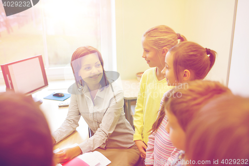 Image of group of school kids with teacher in classroom