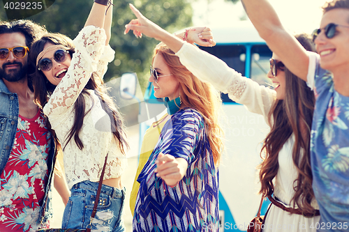 Image of happy young hippie friends dancing outdoors