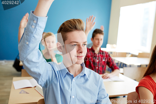 Image of group of students raising hands at school lesson