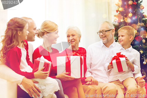 Image of smiling family with gifts at home