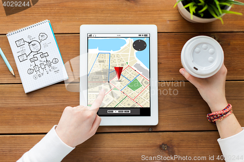 Image of close up of woman with tablet pc on wooden table