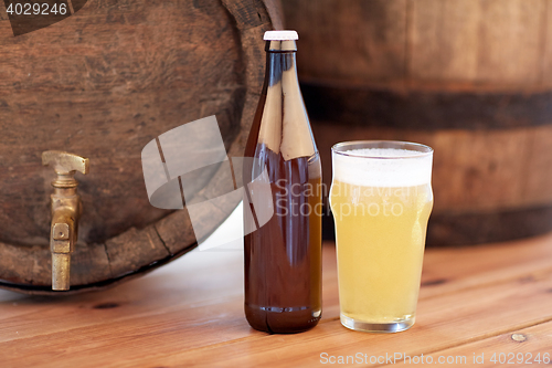 Image of close up of old beer barrel, glass and bottle