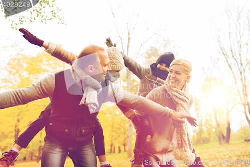 Image of happy family having fun in autumn park