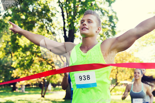 Image of happy young male runner winning on race finish