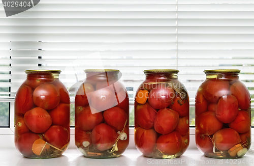 Image of Canned tomatoes in large glass jars.