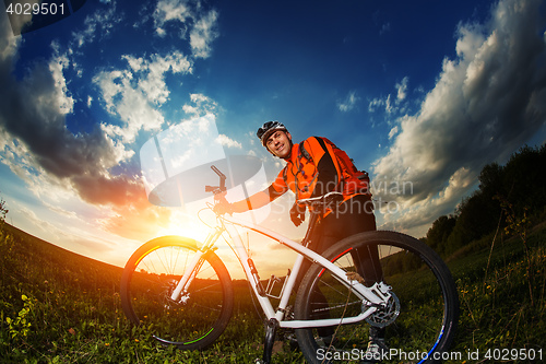 Image of wide angle portrait against blue sky of mountain biker Cyclist