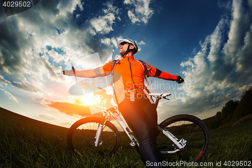 Image of wide angle portrait against blue sky of mountain biker Cyclist