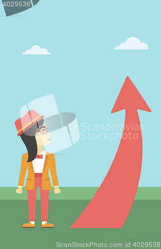 Image of Business woman looking at arrow going up.
