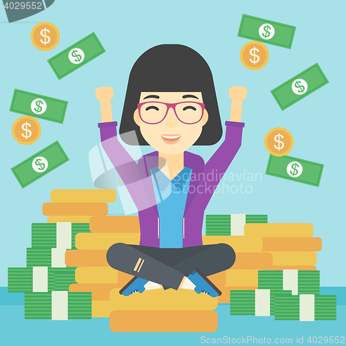 Image of Happy business woman sitting on coins.