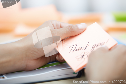 Image of Businesswoman holdings sticky note with Thank you text