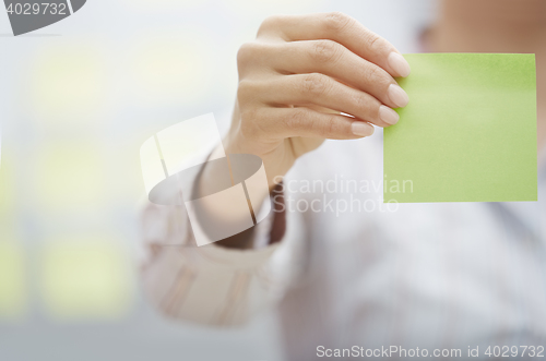 Image of Hand of woman holding sticky note with empty space