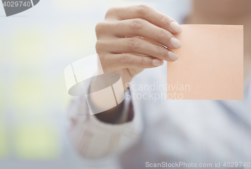 Image of Hand of woman holding sticky note with empty space