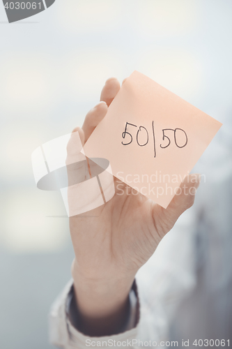 Image of Fifty-fifty text on adhesive note