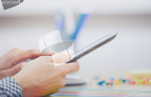 Image of Woman using digital tablet at office