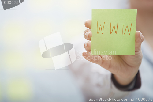 Image of Hands holding sticky note with internet address