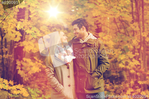 Image of smiling couple hugging in autumn park