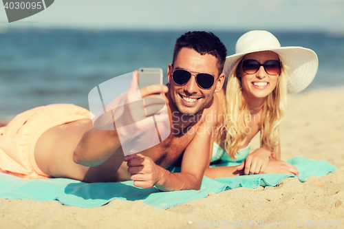 Image of happy couple in swimwear walking on summer beach