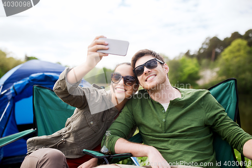 Image of couple of travelers taking selfie by smartphone