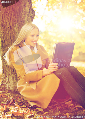 Image of woman with tablet pc in autumn park