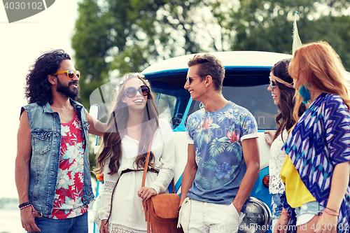 Image of smiling young hippie friends over minivan car