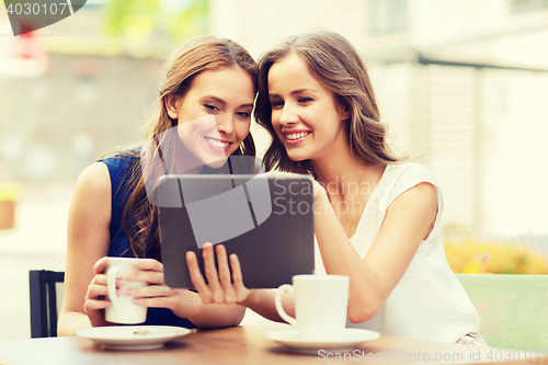 Image of young women with tablet pc and coffee at cafe