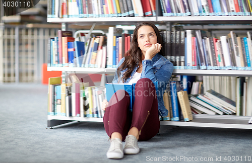 Image of high school student girl reading book at library